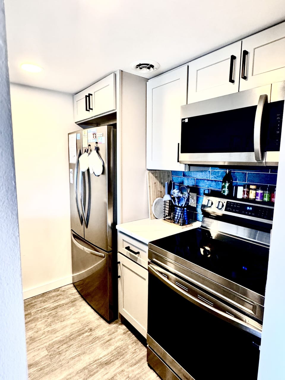 Your fully equipped kitchen awaits with modern stainless appliances, beautiful blue subway tile, and everything needed to create memorable meals together.