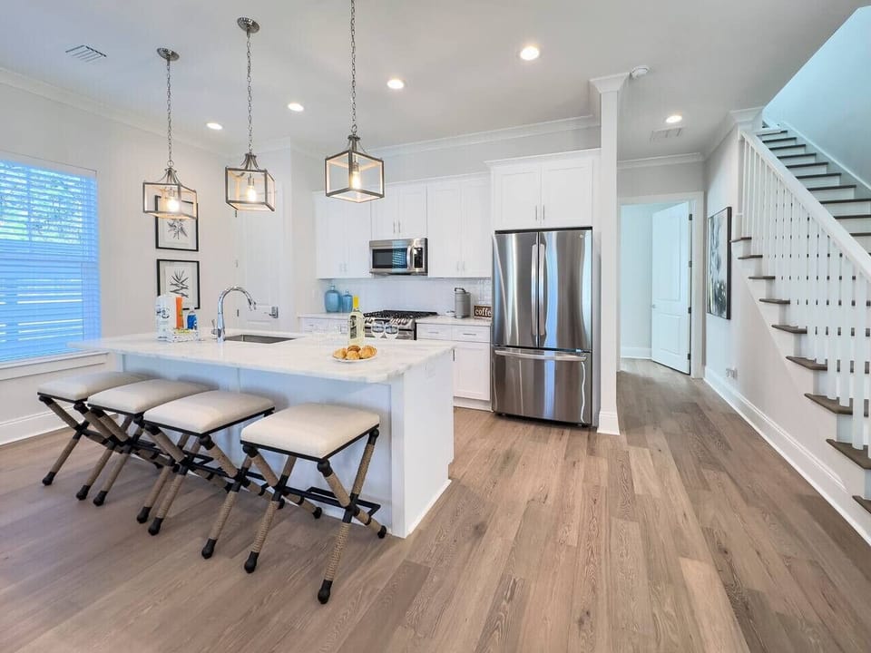 State-of-the-art kitchen with stainless steel appliances, a pantry, and a breakfast bar with seating for four.
