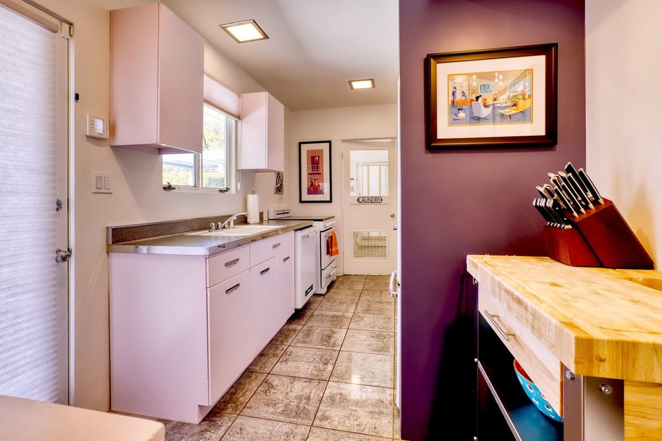 Big kitchen sink with view to backyard.  Vintage aluminum cabinets.  