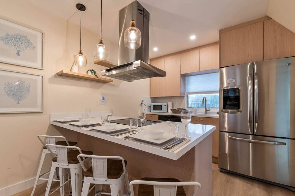 Modern kitchen with stainless-steel appliances, island seating, and everything you need to cook & dine.