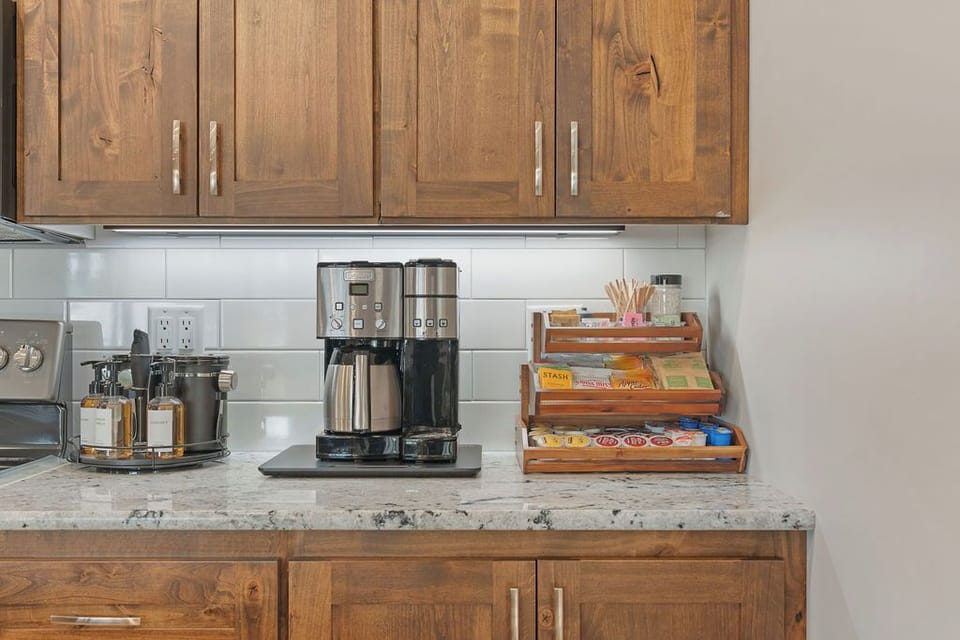Indulge in our Cocoa, Tea, & Coffee Bar. Choose from medium/ dark roast coffee for single pot or cup. Elevate your drink with French Press, frother, coffee grinder, kettle, sugars, & syrups.