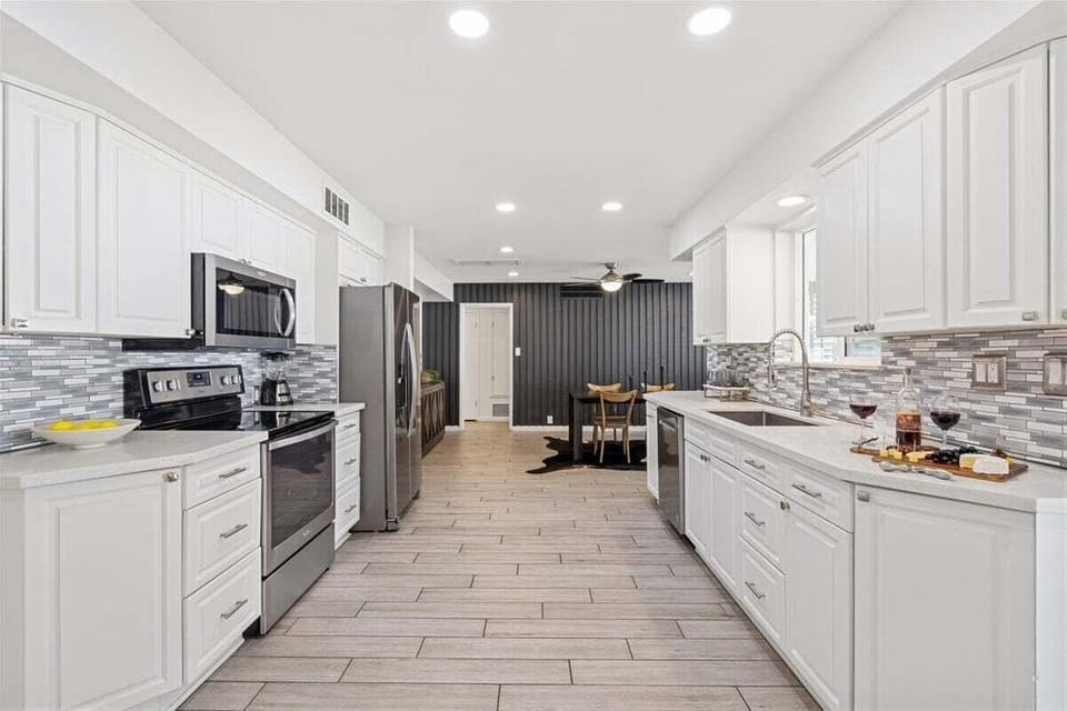 Fully equipped kitchen with stainless steal appliances and access to the backyard.