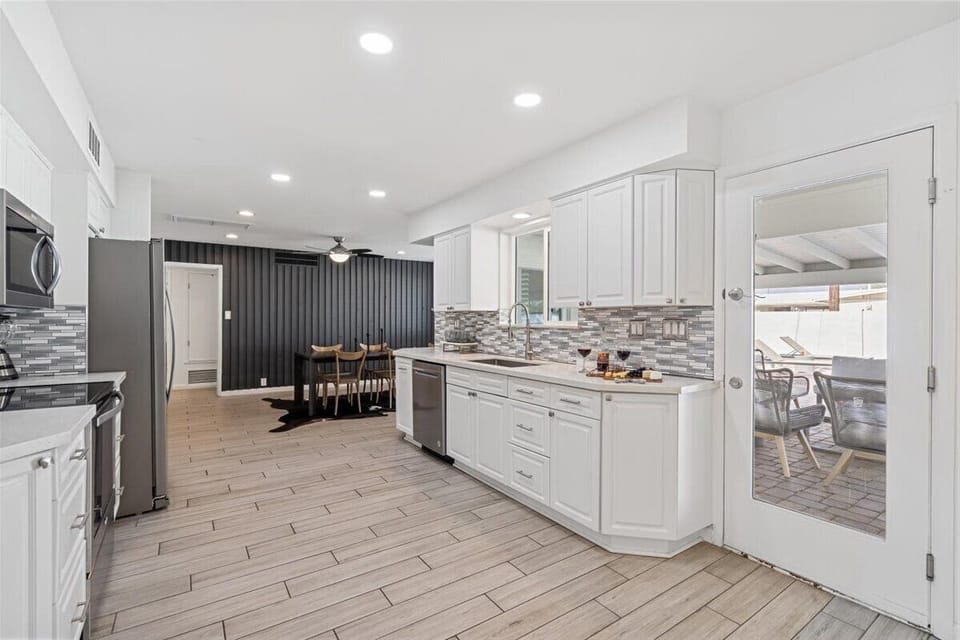 Fully equipped kitchen with stainless steal appliances and access to the backyard.
