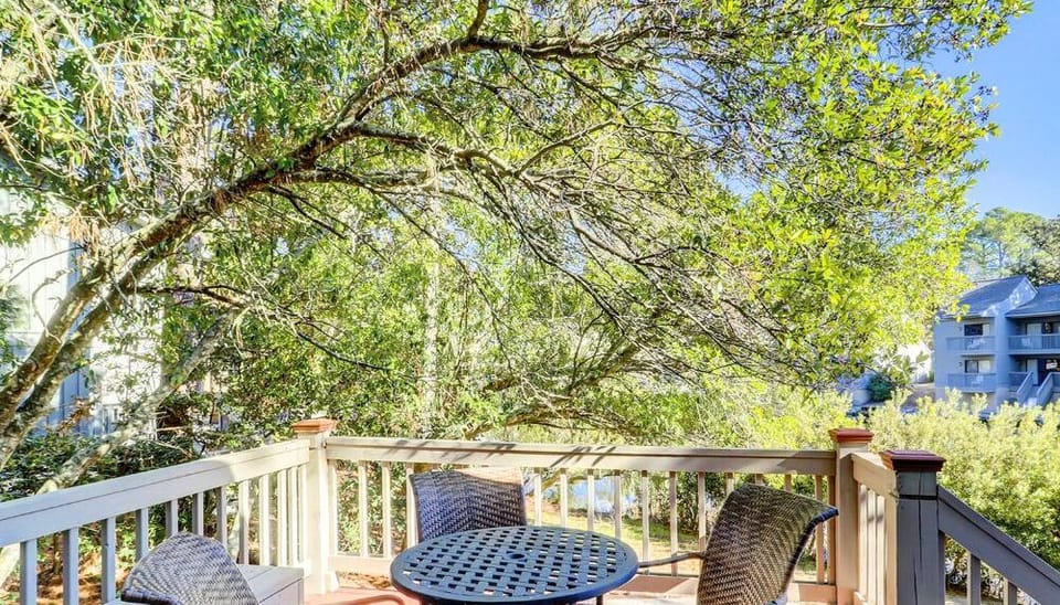 Sip morning coffee on the breezy balcony under leafy shade.