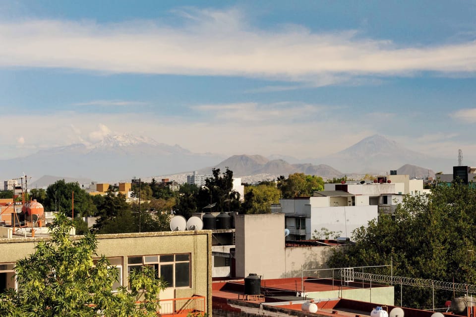 Panoramic city view with mountains in the background.