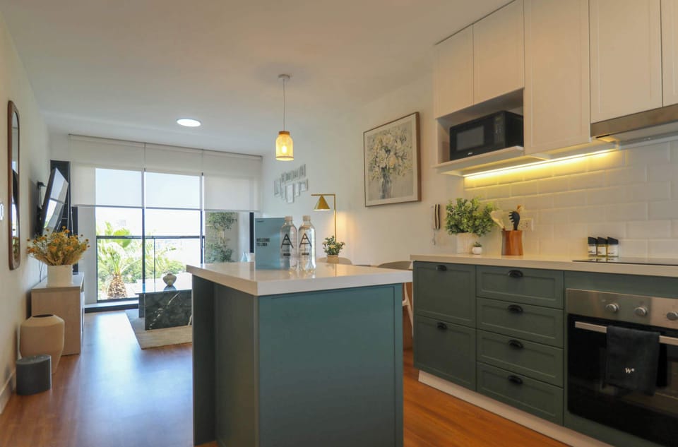 Modern kitchen with green cabinets.