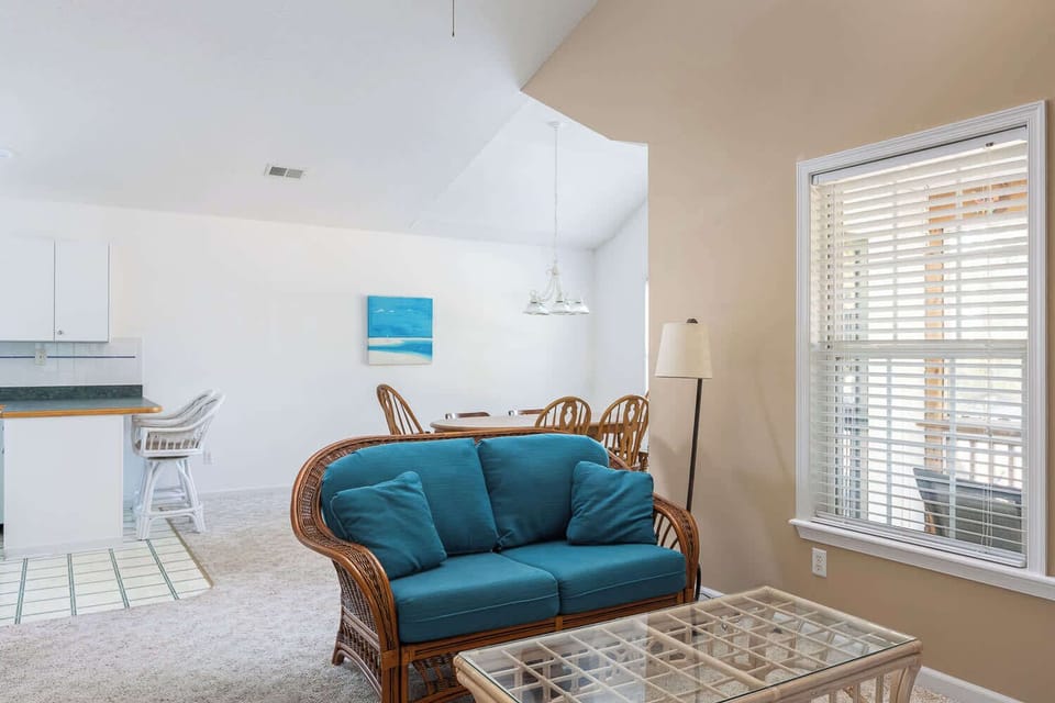 Sunlit living room with cozy seating, ceiling fan and TV