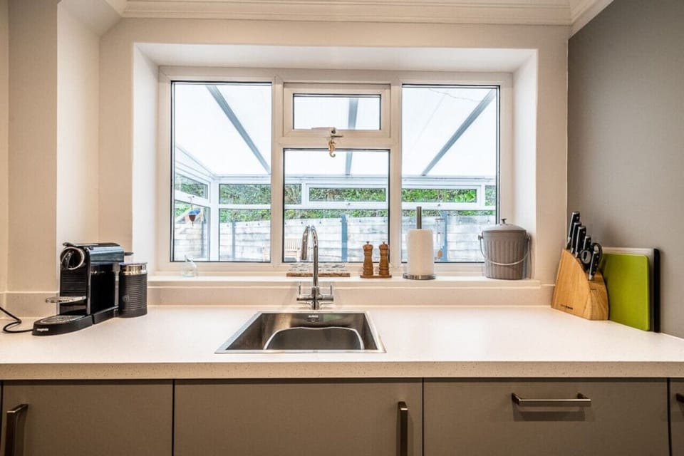 Kitchen looks out to the conservatory and the rear garden beyond