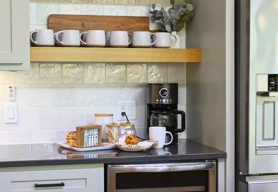 Your morning routine just got an upgrade—this charming coffee bar, with open shelving and a stylish espresso setup, is the perfect way to start your day.
