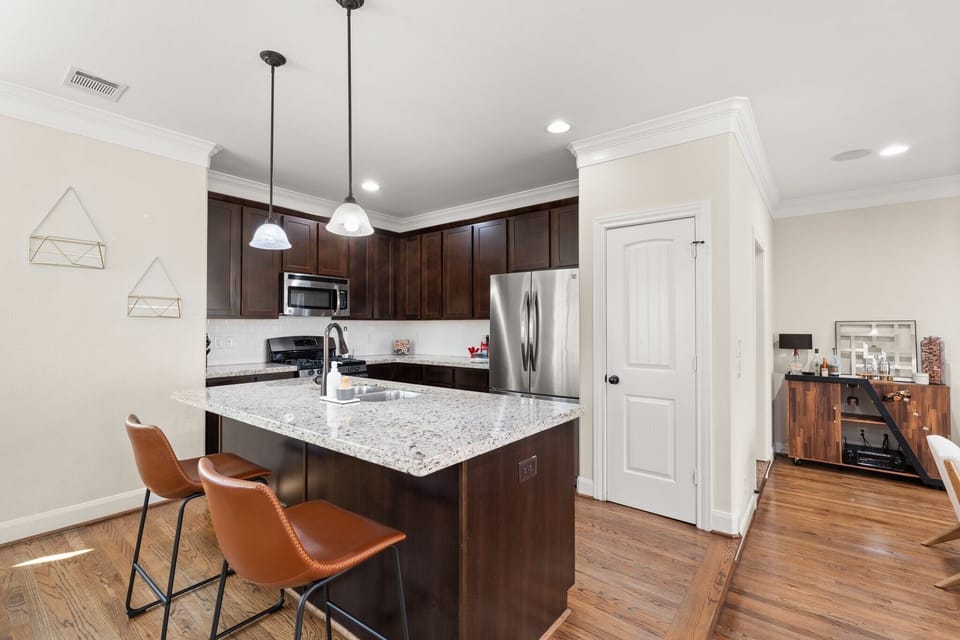 Chef’s kitchen w/ quartz counters & seating for 7.