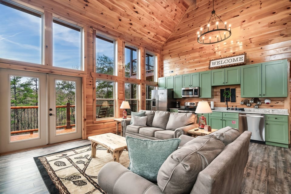 Spacious open-floor concept with vaulted ceiling and floor-to-ceiling windows.