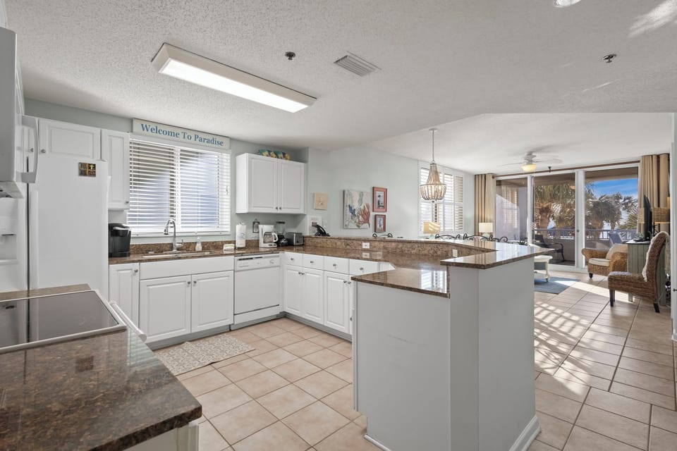 Kitchen - The more than ample kitchen features both small and large appliances including a dishwasher, oven with smooth cooktop, built in microwave, and refrigerator with ice and water in the door. Each cabinet is fully stocked with items needed for preparing meals during your stay.