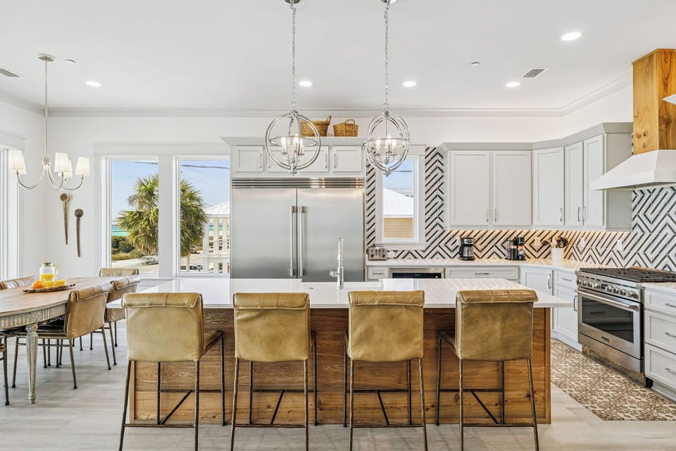 Step into your stunning gourmet kitchen featuring pristine white cabinetry, elegant pendant lighting, and a spacious island perfect for memorable meals together.