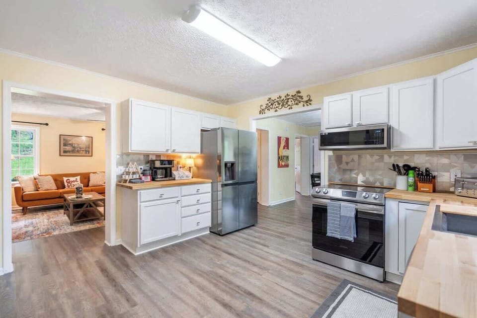 Fully equipped kitchen with utensils, cooking utensils, pots, pans, baking sheets, mixing bowls, plates, bowls, cups, and more!