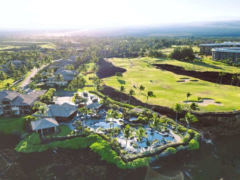 This aerial view captures the tropical blend of lush fairways, cozy villas, and oceanfront style.