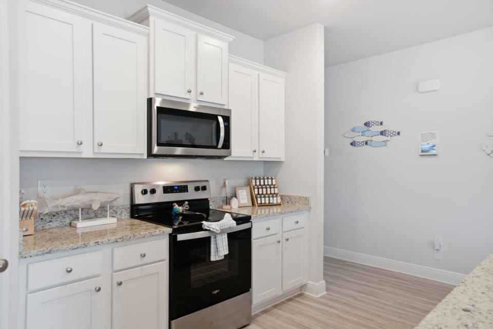 Your fully equipped kitchen features granite counters, modern appliances, and coastal charm—perfect for preparing memorable meals during your stay.
