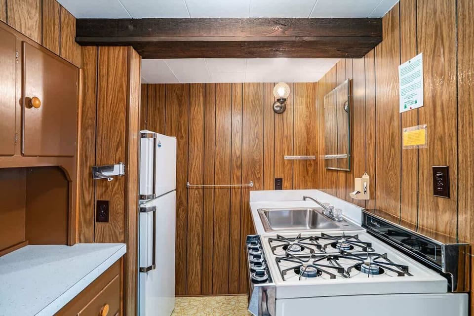 Kitchen includes fridge, sink, stove, and gas top.