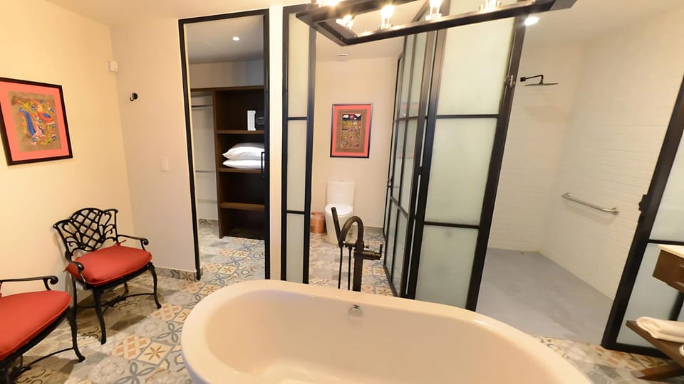Vista Encantada bathroom with tub, seating, and walk-in shower.