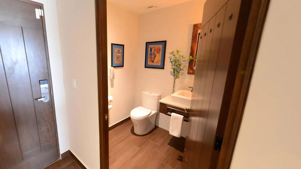 Vista Encantada half bath with modern design and colorful artwork.