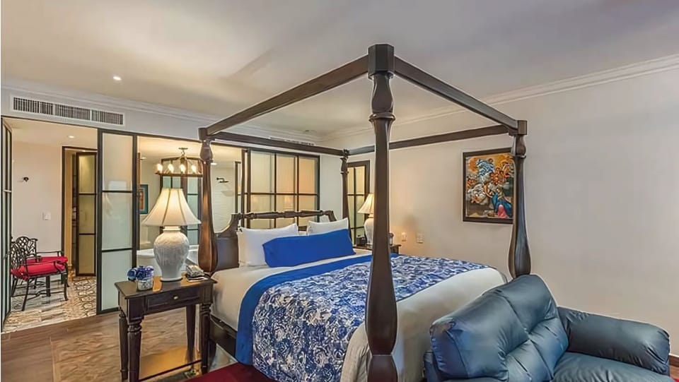 Elegant king suite with four-poster bed and modern Mexican décor.