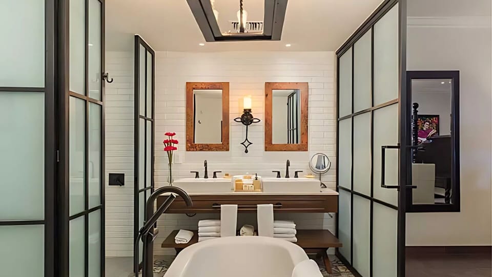 Luxury bath with soaking tub, double sinks, and frosted glass doors

