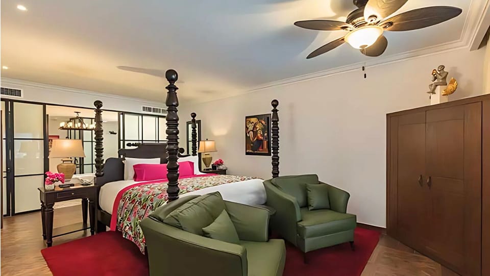 Vista Encantada suite with king canopy bed and cozy seating area.