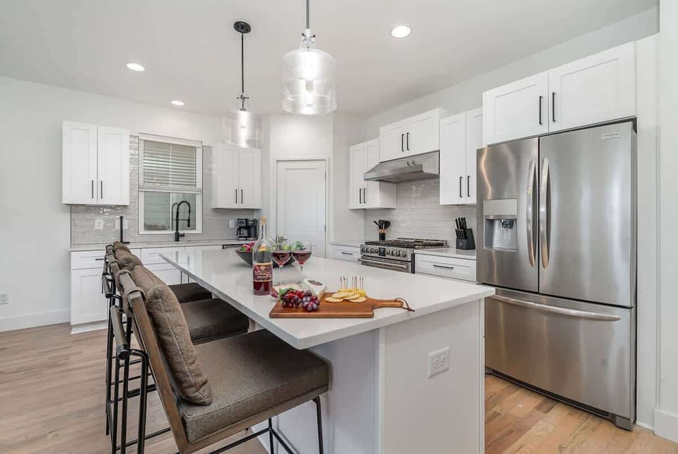 A bright and modern kitchen with sleek appliances and plenty of counter space, perfect for preparing meals or enjoying casual snacks.