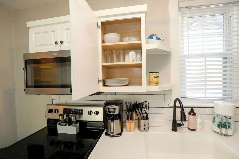 Kitchen showing inside of the cabinet where plates, cups and bowls are located. 