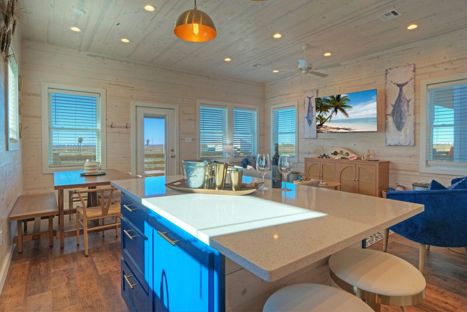 Bright, open-concept living with a spacious island, coastal décor, and easy access to the patio for seamless indoor-outdoor living.