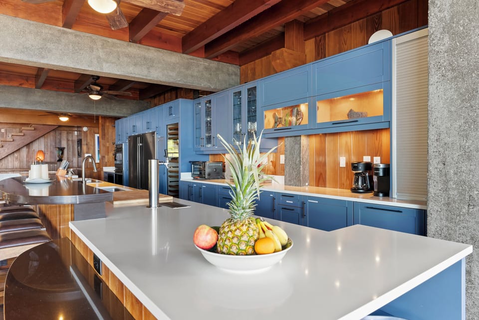 The gourmet chef's kitchen features oversized islands, custom cabinetry, premium appliances, and generous prep space designed for entertaining.