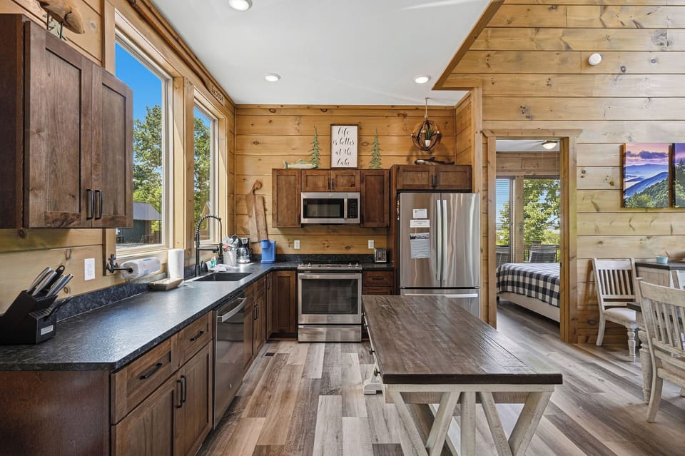 Gather around this beautiful rustic kitchen featuring modern appliances, rich wood accents, and warm mountain cabin charm.