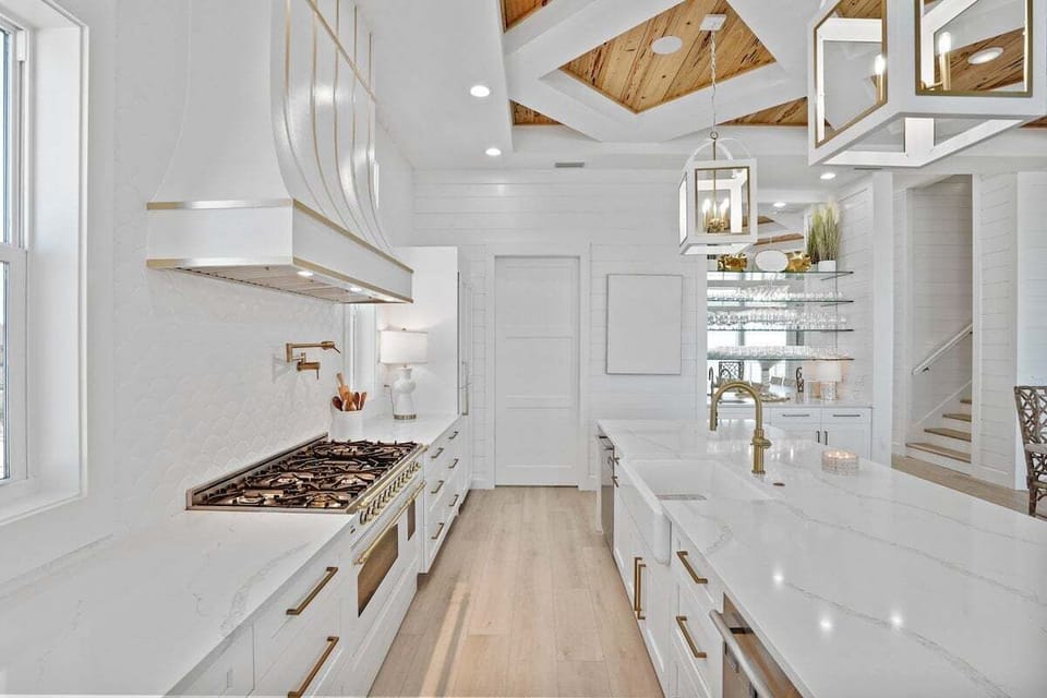 This gourmet kitchen boasts high-end appliances, sleek white cabinetry, and a stunning marble island, making it a chef's dream.