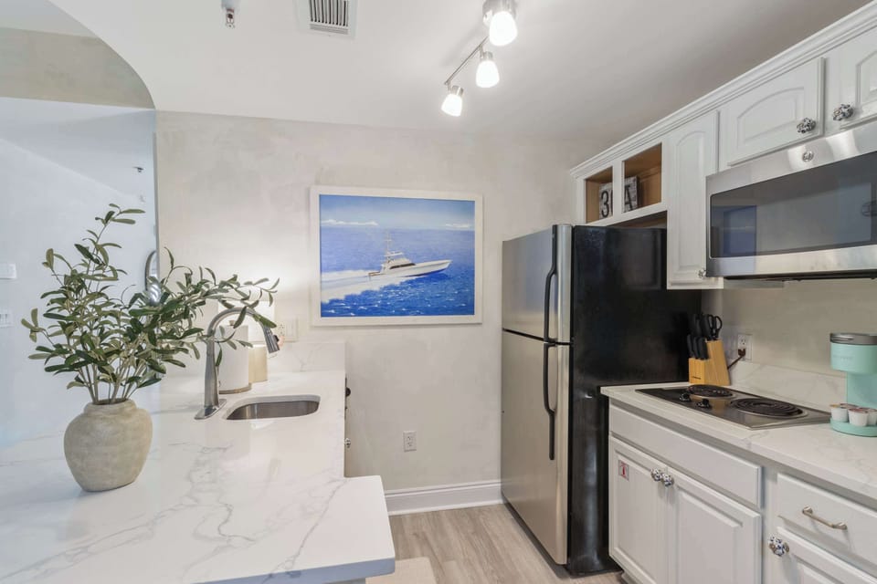 Kitchen: Bar seating, stovetop, microwave, refrigerator, drip coffee maker, cookware & dinnerware