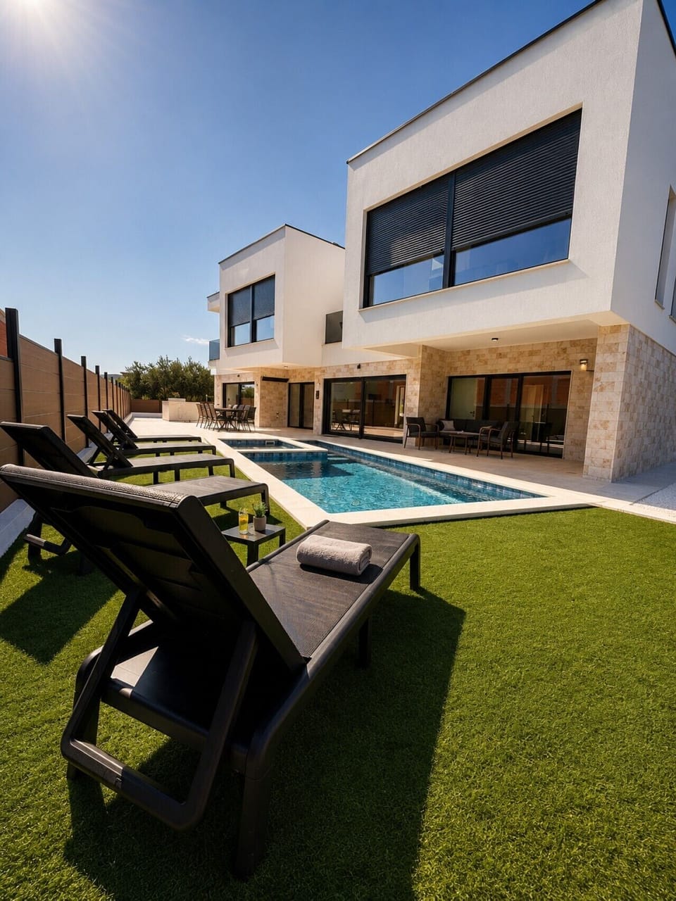Sun-Drenched Pool Deck with Loungers on Green Lawn