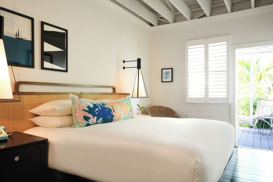 Unwind in crisp linens with breezy balcony views outside.