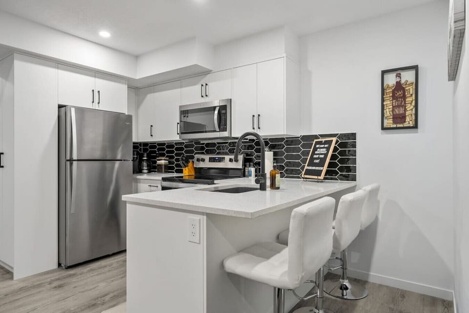 Full kitchen with drip & Keurig coffee makers, and island seating.