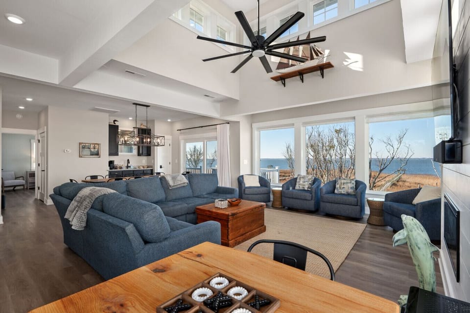 Open living space w/ plush sofas, vaulted ceilings, & sunlit windows made for relaxed coastal gatherings