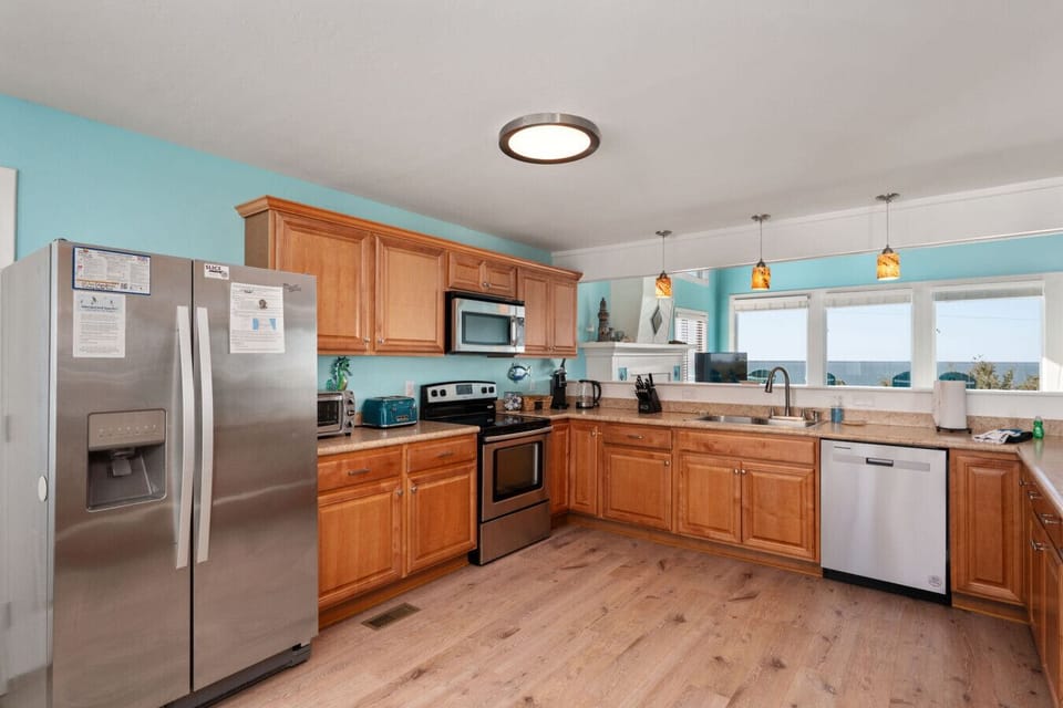 Spacious kitchen w/ wood cabinetry, stainless appliances, & generous counter space.