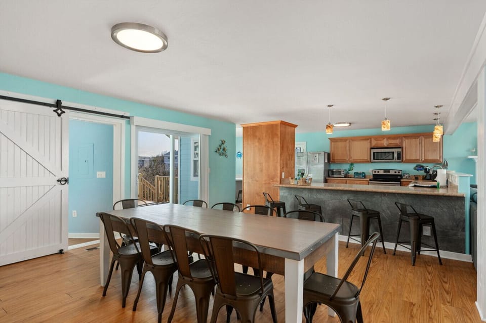 Open dining area w/ long table & bar seating, perfect for shared meals & gatherings.