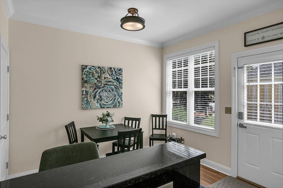 Enter through the back door into the dining area, featuring a 4-seat dining table and 2 bar stools at the kitchen island for added seating.
