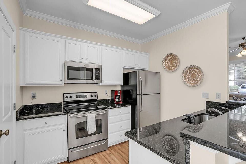 Look left to find the kitchen, equipped with stainless steel appliances including a fridge & freezer, electric stove top & oven, dishwasher, and microwave. A coffee maker is also available for your convenience!