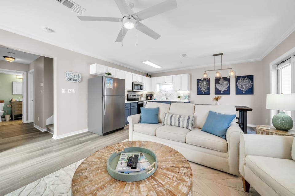 Relax in this bright, coastal-inspired living space with modern comforts, stylish décor, and an open layout that blends seamlessly with a fully equipped kitchen.