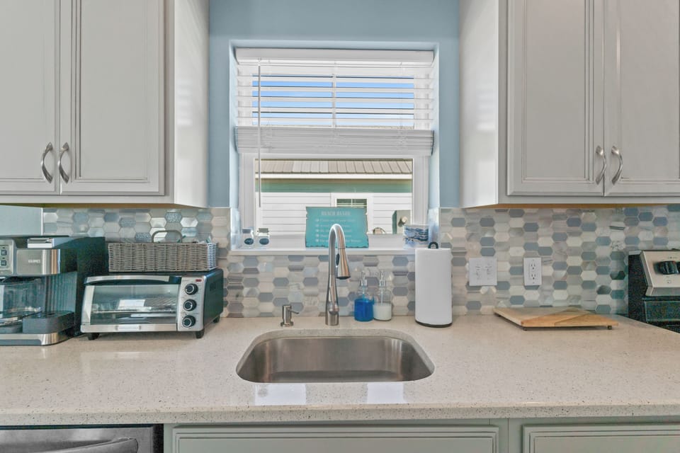 Your fully equipped kitchen features modern appliances and stylish hex tile backsplash, perfect for preparing meals during your stay.