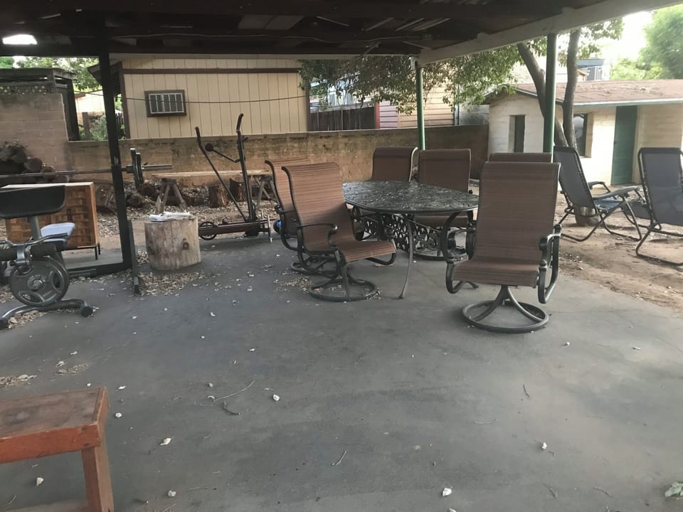 Relaxing covered area with firepit, work out equipment, and rocking chairs
