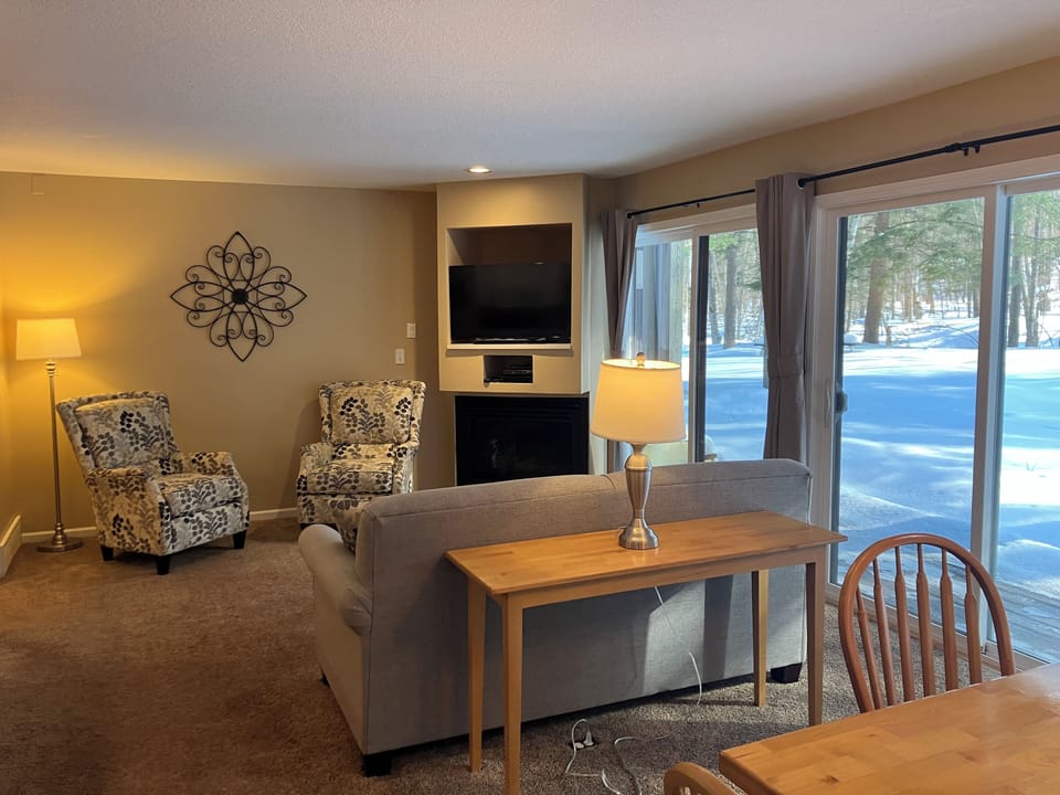 Living Room with gas fireplace, tv, sleeper sofa & 2 cushioned chairs 