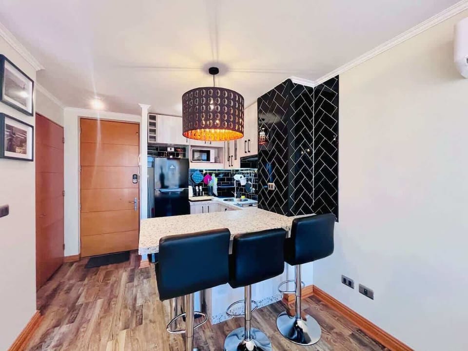 Dining area w/ round table, pendant light & open layout.