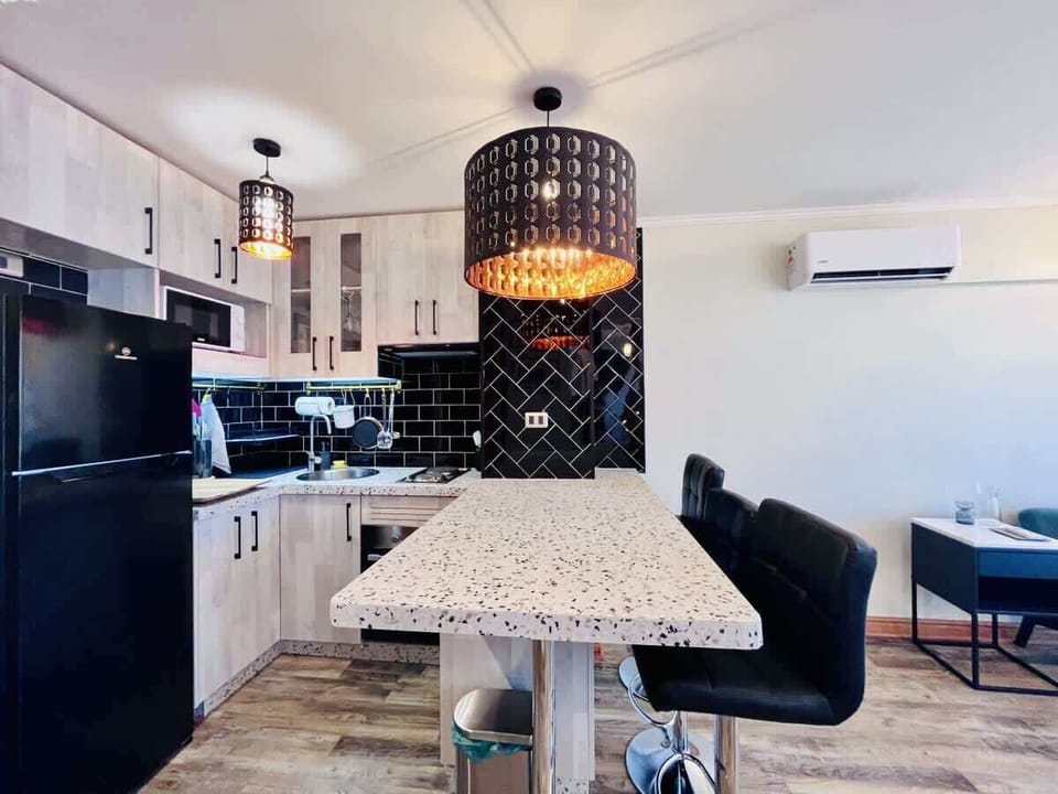 Modern kitchen w/ sleek cabinets, breakfast bar & stylish pendant lighting.