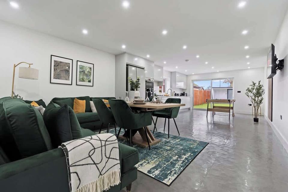 Comfy sofa in a well sized open plan kitchen living room space with dining table and pool table 