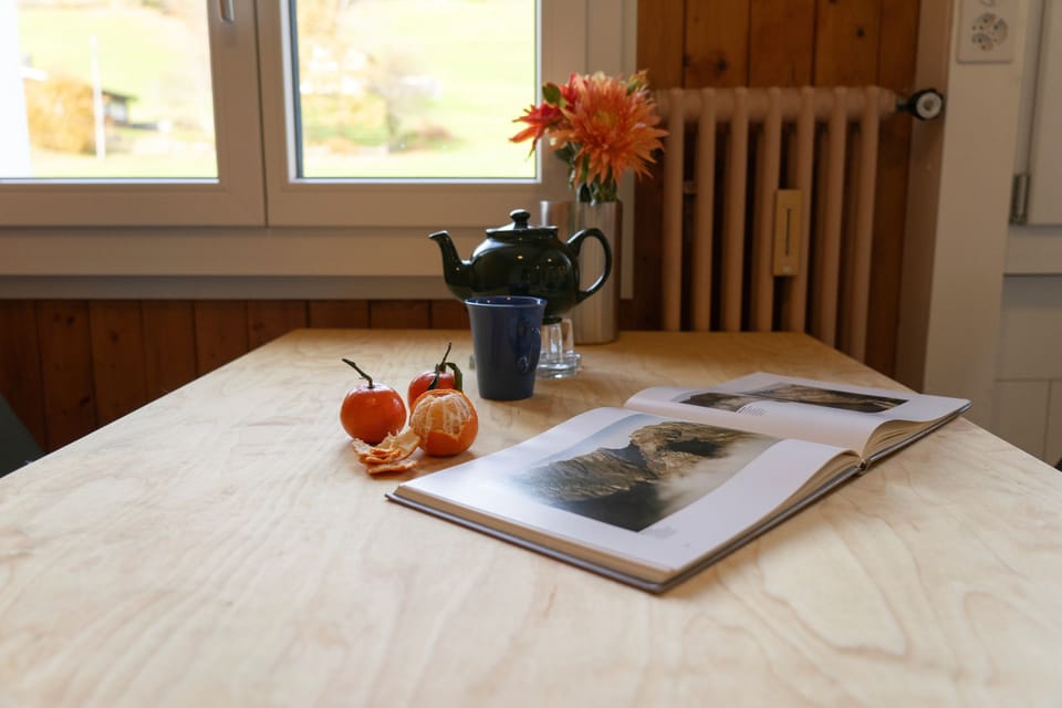 Dining table with tea, flowers and photo book