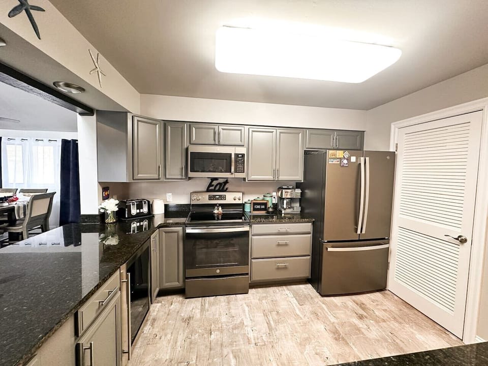 The kitchen includes a side-by-side refrigerator, built-in microwave, oven, and dishwasher for your convenience.